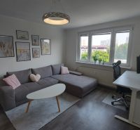 Living room with a corner sofa, a desk, and a floor with a wooden decor.