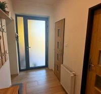 Entrance hallway in a family house with a wooden decor floor and a coat rack.