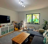 Living room in a family house with a large window and a wooden decor floor.