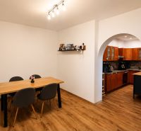 Dining room and kitchen in a family house with a wooden decor floor.