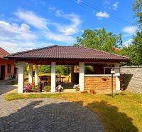 A garden in a family house in Iža with a gazebo and garden flowers in a brick design.