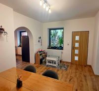 The interior of a family house with a wooden decor floor, light-colored walls, and a children's corner.