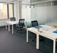 Offices with white desks, comfortable chairs, and a large window.