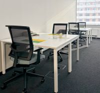 The interior of offices with white desks and black chairs, suitable for work.