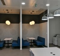 Offices with conference tables, blue sofas, and pendant lights for comfortable meetings.
