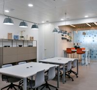 Offices with wood-patterned flooring, conference tables, and pendant lights.
