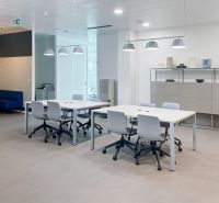 Offices with white desks, gray chairs, and a wooden-patterned floor.
