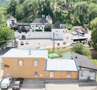 Commercial premises in Divín with a view of historical architecture and greenery.