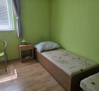 A room with a bed, a table, and a floor with a wooden decor in commercial premises.