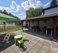 In Divín, there are commercial spaces with a garden seating area and a children's playground.