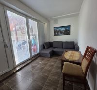Commercial space with a sofa, table, and chair, tiles imitating wooden decor.