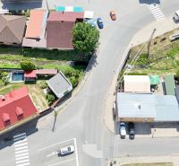 A top view of commercial premises in Divín with steep roofs and an adjacent green plot.