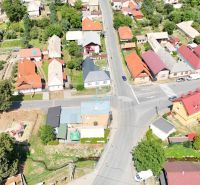 Aerial view of houses and roads in the village of Divín surrounded by greenery.