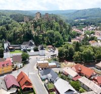 Aerial view of the ruins of the castle and houses in Divín, commercial spaces in the foreground.