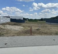Residential plots in Lučenec, an empty building plot between houses, blue sky.