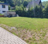 A grassy plot in the Recreational Lands of Valkov in Bžany, surrounded by trees and houses.
