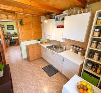 A kitchen in a cabin with a wood-patterned floor, full of storage shelves and elements.
