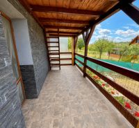 Veranda of the cottage in Skalica with a view of the garden and stone walls.