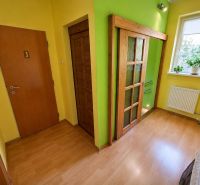 In the family house, there are yellow walls and a floor with a wooden design.