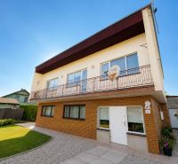 A family house in Bytča with a garden, two floors, brick facade, and a balcony.