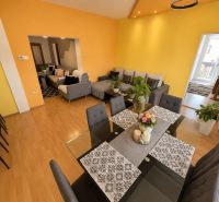 Colorful interior of a family house with a sofa and a dining table, floor with wooden decor.