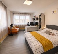 Bright bedroom in a family house with wood-patterned flooring and decorative elements.