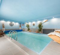 An indoor swimming pool in a family house with nautical-themed decorations.