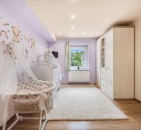 Children's room with pastel walls, a crib, and a wooden decor floor.