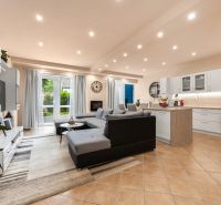 Living room with kitchen in a family house, light floor, large sofa.