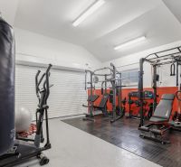 Home gym with exercise equipment, including a treadmill and a punching bag.
