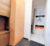Bathroom in gastro premises with white tiles and a black and white curtain.