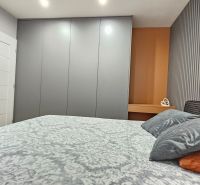 Bedroom in a 2-room apartment with a large wardrobe and decorative accessories.