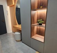 Entrance hall in a 2-room apartment with shelves and wooden decor flooring.