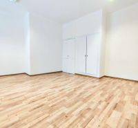 A bright room in offices with white walls and a floor with a wooden decor.