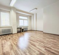 Offices with large windows, wood-patterned flooring, and wall radiators.