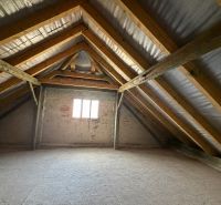 Attic space in a family house with a wooden beam roof system.