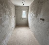 Unfurnished room in a family house with unfinished walls and a concrete floor.