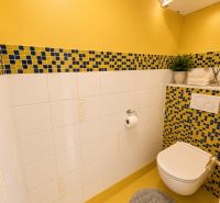 A bathroom with colorful tiles and a wall-hung toilet in a 3-room apartment.