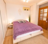 A bedroom in a 3-room apartment with a bed, a cabinet, and a floor with a wooden decor.