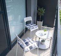 Balcony in a studio apartment on Zuzany Chalupovej Street in Bratislava - Petržalka with white furniture.