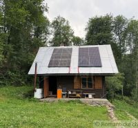 A family house in Kokava nad Rimavicou with wooden shutters and solar panels on the roof.