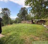 The garden of a family house in Kokava nad Rimavicou with a lawn and a view of the forests.