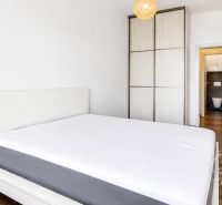 Bedroom with a wardrobe and wooden decor flooring in a 3-room apartment.