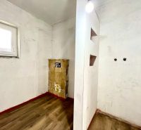 Interior of a family house with a wooden decor floor and a window on a white wall.