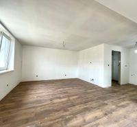 A spacious room in a family house with a wooden decor floor.