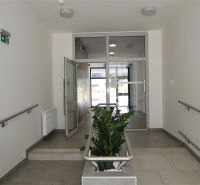 A hallway with tiles, railing, and flowers in a 2-room apartment.