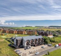 Veľká Lomnica, Futbalová: apartment complexes surrounded by greenery, cars, and a children's playground.