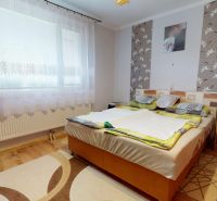 Bedroom in a 3-room apartment with a wooden decor floor, light and decorative walls.
