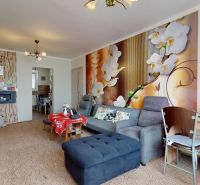 Living room in a 3-room apartment with floral wallpaper and comfortable seating.