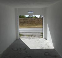 A garage with white walls and a concrete floor overlooking Ľudovíta Stárka in Trenčín.